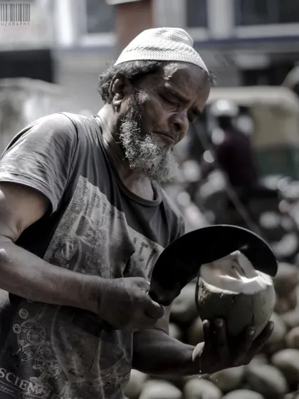 The concentration of a coconut vendor at work. I focus on capturing the skill and effort that goes into everyday jobs, turning a simple action into a compelling portrait.