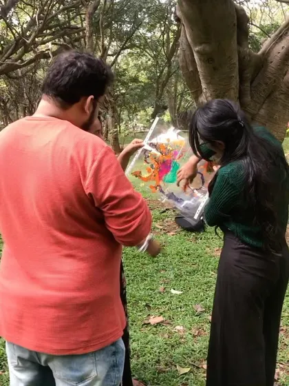 Two participants collaborating on a piece of art during our park session. Art is a wonderful language for connection.