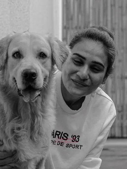 A beautiful black and white portrait of a woman and her golden retriever, capturing a moment of quiet companionship.