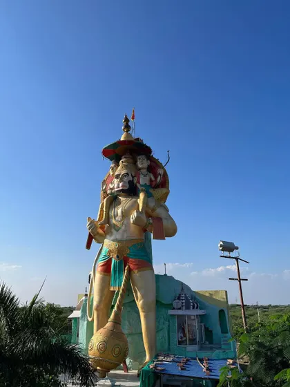 A distant view of the Hanuman statue, showing its scale in relation to the surrounding landscape.