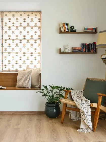 The cozy bay window niche in the 'House of Kismish' primary room, complete with a comfortable armchair and bookshelves. It's a perfect spot for reading and relaxing.