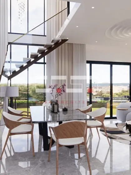 Another angle of the duplex living room, showing the bird-themed wall decor along the staircase and the harmonious blend of colors and materials.