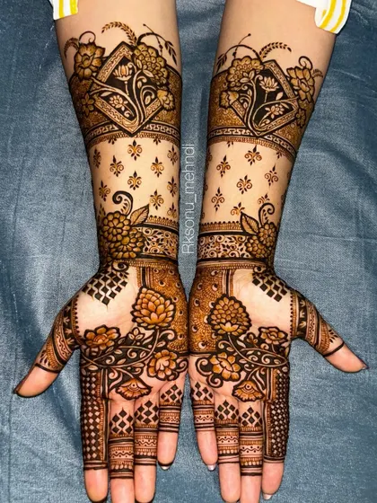 A gorgeous floral design that extends up the arm. The use of negative space with scattered motifs on the forearm contrasts beautifully with the denser patterns on the palm.