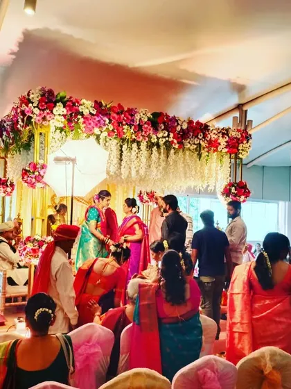 A candid moment from a wedding ceremony, captured under the beautiful floral mandap we designed. It shows how our decor becomes the perfect backdrop for the most important rituals.
