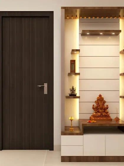 This pooja unit is built into a wall niche, saving floor space. It features multiple illuminated shelves for idols and a clean, white cabinet for storage.