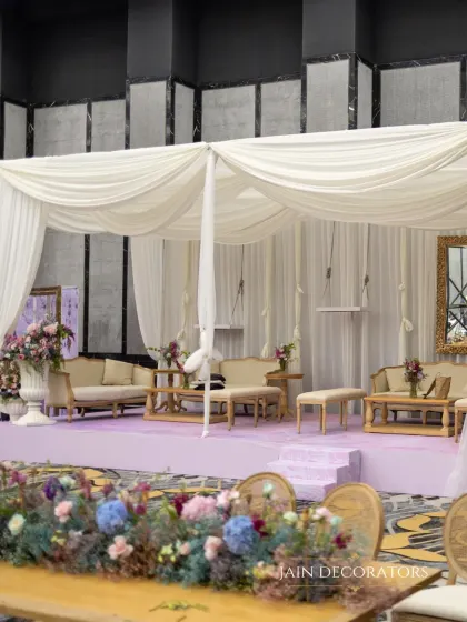 A serene and sophisticated lounge area. I used soft white drapes to create a canopy over plush seating, all set on a lavender stage for a look that is both calming and incredibly chic.
