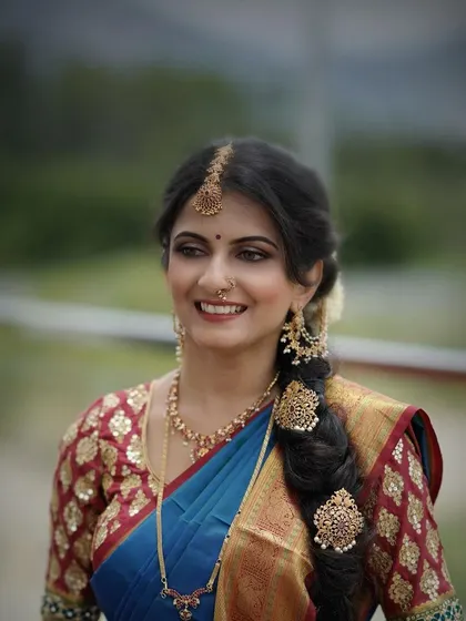 This bride's look is complemented by a traditional braided hairstyle with intricate gold accessories. The makeup is kept classic to balance the entire look.