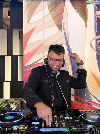 A candid, smiling shot of me adjusting my headphones, ready for the next transition. This shows my relaxed and confident approach during a live set.