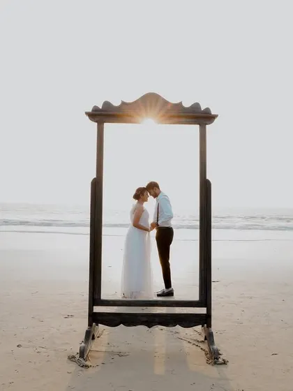 A creative pre-wedding concept on the beach. Using props like this vintage mirror allows us to play with reflections and framing, creating artistic and unique couple portraits against the serene ocean backdrop.
