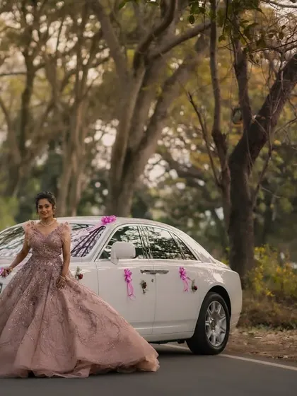 A grand bridal portrait featuring a Rolls Royce. This image speaks of modern luxury and fairytale entrances, capturing the bride in her magnificent reception gown.