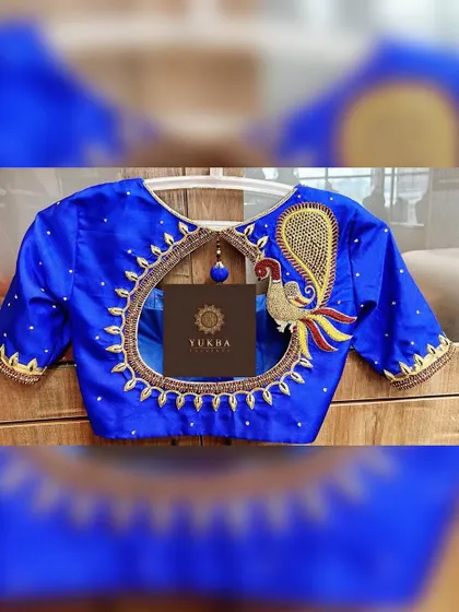 This design is all about making a bold statement. A majestic peacock motif, crafted with zardosi and resham embroidery, becomes the centerpiece of this royal blue blouse, framing an elegant circular back cutout.