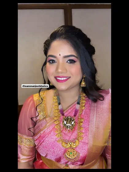 The bride's sister looks stunning with her pink-themed makeup and traditional gold jewellery.