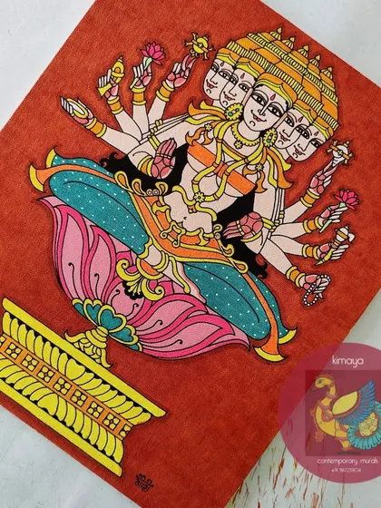 The completed Sri Gayatri Devi painting on a 12x14 inch canvas. The vibrant colors against the textured orange background highlight her divine, multi-faceted form, seated gracefully on a lotus.