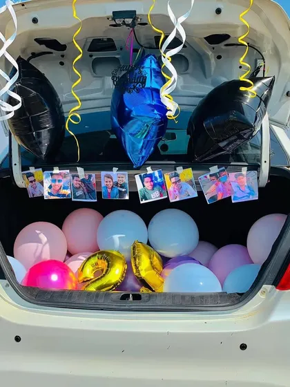 A personalized car trunk decoration featuring balloons and a string of cherished photos, making the surprise extra special and meaningful.