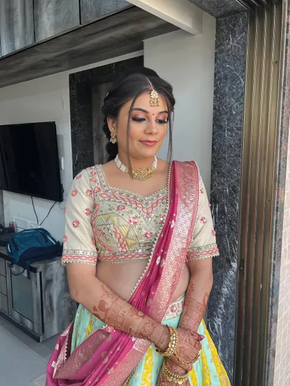 A full view of this lovely baby shower look, with a pastel lehenga and a neat updo.