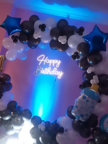 Celebrating a baby boy's first birthday with a classic blue, black, and white balloon ring, complete with a 'It's a Boy' foil balloon.