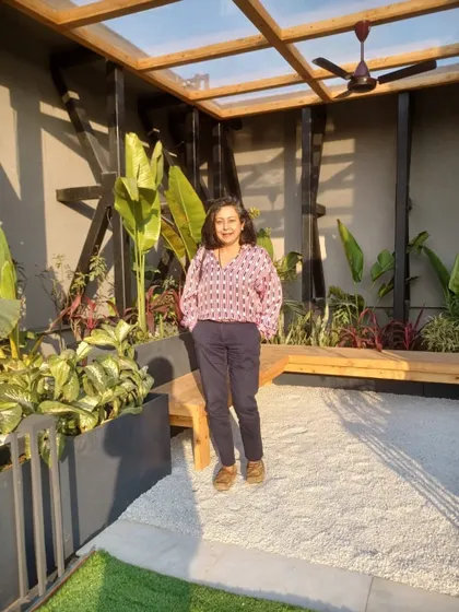 A glass covered seating area in the corner of a roof. This structure protects the tropical plants from frost during the winter nights while creating a cozy, sunlit nook.