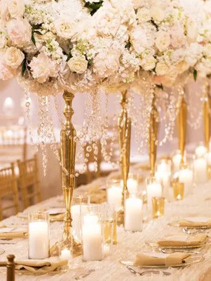A luxurious table setting with towering floral arrangements and crystal-draped candelabras. This showcases our commitment to creating opulent and memorable dining experiences, where every element on the table contributes to a feeling of grandeur.