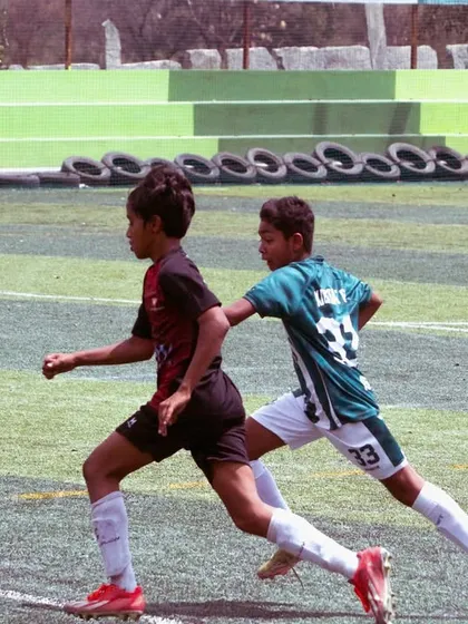 A young player races down the wing, battling a defender for the ball. This is the kind of one-on-one duel we prepare our players for.