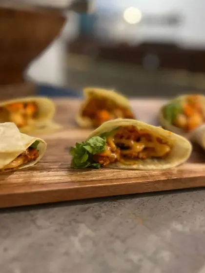 Another shot of our mini tortilla wraps, showcasing their neat presentation on a wooden board. These are a versatile option that can be customized with various fillings.