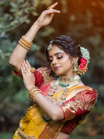 The artistry of a bridal pose, highlighting the intricate details of the blouse and the traditional hairstyle.