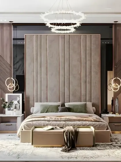 A luxurious bedroom design with a grand, floor-to-ceiling upholstered headboard. The room is designed for comfort and style, featuring elegant pendant lighting and a plush bench at the foot of the bed.