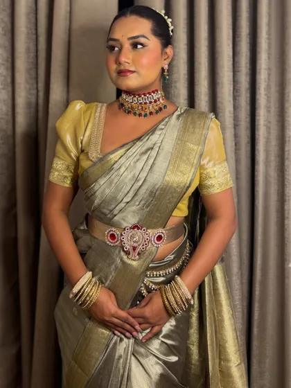 A full look in a beautiful grey and gold Kanjivaram-style saree. This ensemble is perfect for hosting a traditional wedding ceremony or reception.