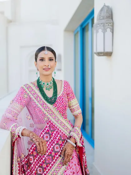 A portrait showcasing the details of this beautiful look. The skin is luminous, the eyes are softly defined, and a classic red bindi completes the traditional aesthetic.