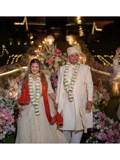A moment of pure happiness as the newlyweds walk hand-in-hand down the aisle at their Mussoorie wedding. The smiles on their faces are illuminated by the warm glow of the lights, surrounded by friends, family, and flowers.