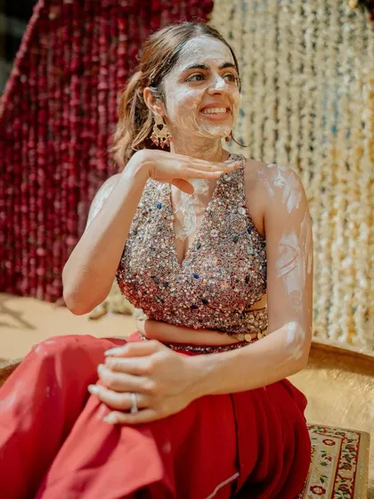 A beautiful, serene moment from the Haldi ceremony. The bride, Hayati, looks peaceful and happy as she gets smeared with haldi, a quiet moment before the colorful chaos begins.