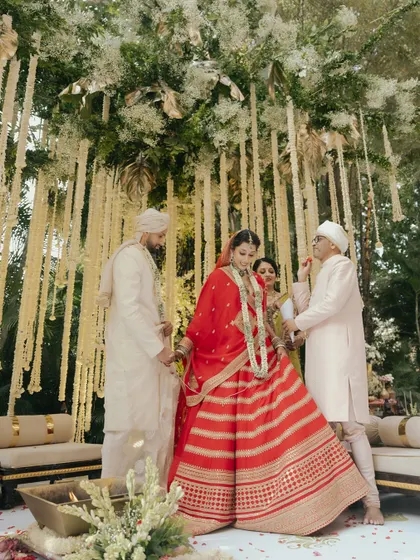 A sacred moment from Avin and Nikki's ceremony, as they are blessed by their family under a beautiful floral mandap.