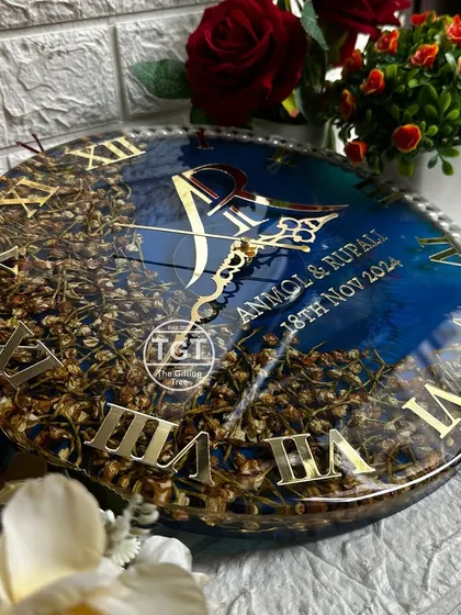 An angled view of the navy blue resin clock, showing the depth and dimension of the preserved flowers. The golden Roman numerals and custom monogram stand out beautifully.