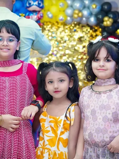 A group of three young girls posing together at a party. Capturing the friendships and fun moments between kids is a big part of what we do.