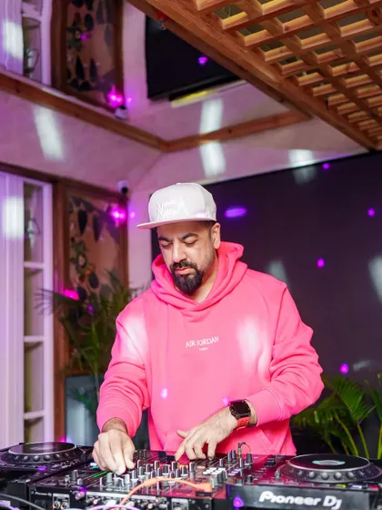 Back on the decks in a fresh fit, ready to drop more timeless beats for the legendary Monkey Bar crowd.