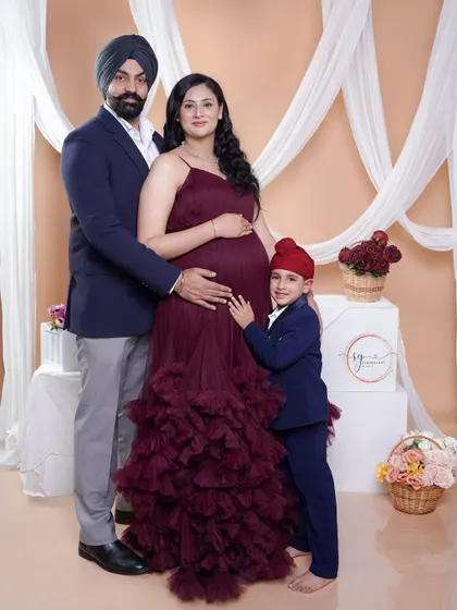 A beautiful family portrait celebrating the next chapter. The whole family, including the excited older brother, gathers around to celebrate the coming arrival, creating a complete family memory.