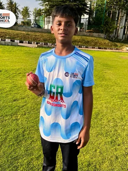 A young bowler holds up a cricket ball, ready to learn and compete at our residential summer camp.