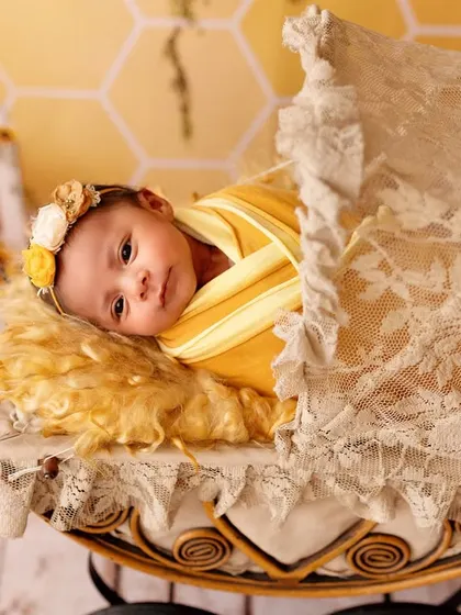 This awake newborn looks so peaceful in a vintage-style pram during her sunflower-themed shoot. I always follow the baby's lead, whether they are asleep or awake.