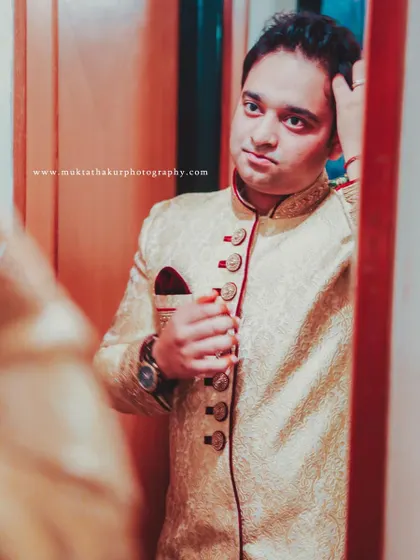 The final check in the mirror. A candid moment of the groom getting ready for his wedding day.