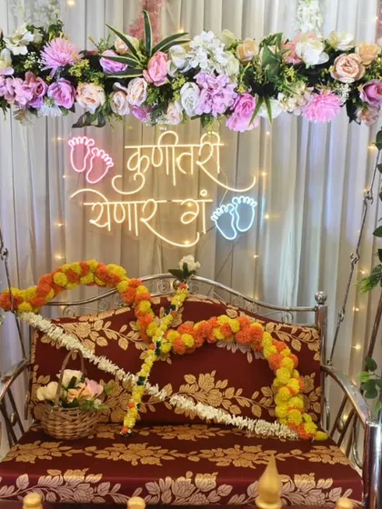 A classic and elegant Dohale Jevan setup. The floral arch around the jhula and the 'Kunitari Yenar Ga' neon sign create a perfect, timeless look for the ceremony.