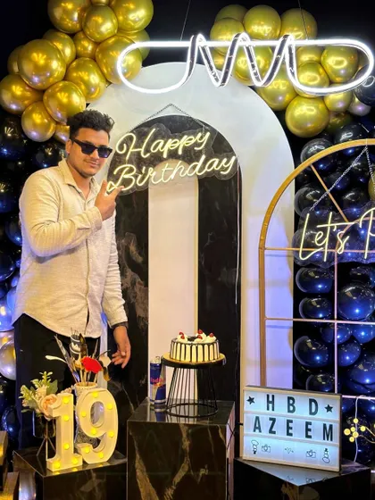 Pointing to the "Happy Birthday" sign, this guest is all smiles. Our custom neon signs and decor elements like the light-up "19" make every birthday feel personal and special.