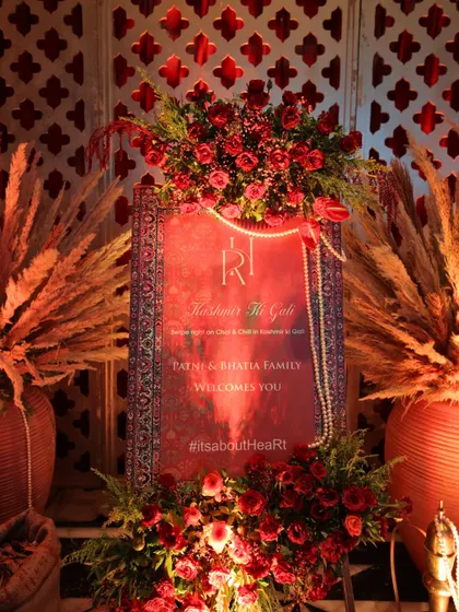 The welcome signage for the "Kashmir Ki Gali" event, designed to look like a rich carpet and adorned with red roses and pearls, immediately immersing guests in the theme.