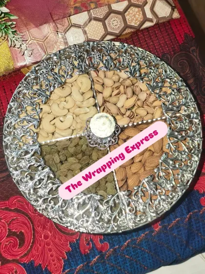 A classic dry fruit platter with four sections for cashews, pistachios, almonds, and raisins. The ornate silver tray makes it a very elegant gift.