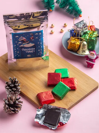 Our Christmas Chocolate Chikkis, wrapped in festive red and green foil. This modern twist on a traditional sweet adds a delightful crunch to your holiday celebrations.