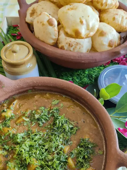 Another view of our Gangaur Teej special, featuring a delicious potato curry served with soft, puffed puris, perfect for festive meals.