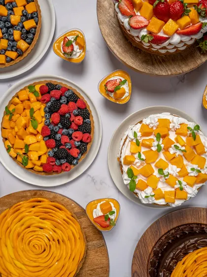 A stunning spread of my seasonal mango and berry creations. This image shows the variety in my summer menu, including tarts, cakes, and mini desserts.