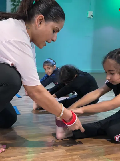 Helping students achieve a deeper forward bend. This not only improves hamstring flexibility but also teaches them patience and body awareness.