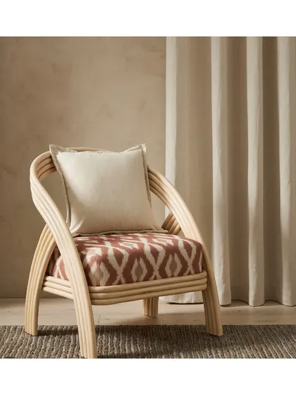 I love using classic patterns like this 'Adra' ikat fabric to add a touch of worldly sophistication. Upholstering the seat of this rattan chair creates a beautiful contrast between the natural frame and the bold textile.