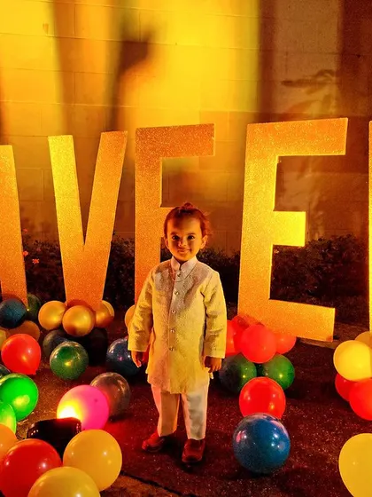 The best part of my job is seeing the birthday kid's smile. Here's the little star, Aveer, standing proudly in front of the giant, golden letters of his name at his Winnie the Pooh party.