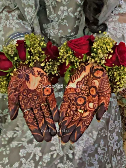 The beautiful henna stain on an engagement look, adorned with floral jewelry.