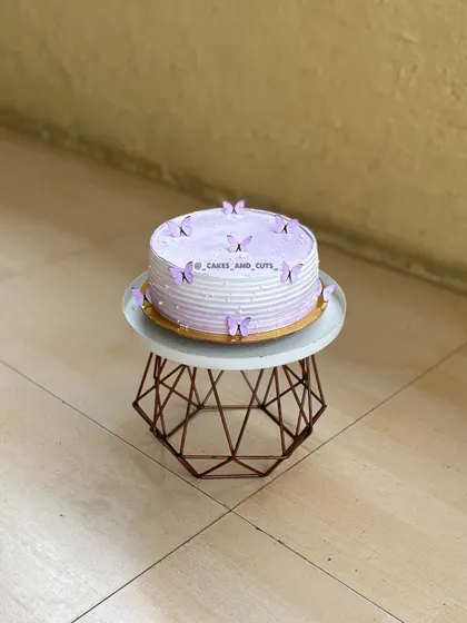 The full view of the lavender butterfly cake on its stand, a perfect design for any girl's birthday.